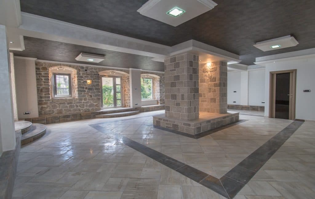 a spacious room with a marble floor and stone walls