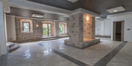 a spacious room with a marble floor and stone walls